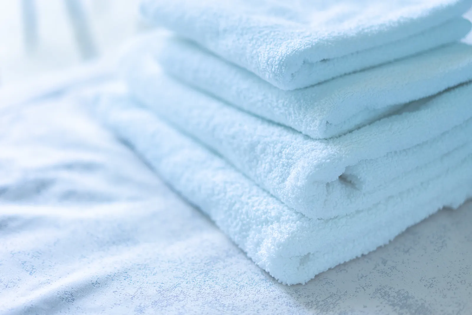 Soft white towels neatly stacked in a clean spa setting