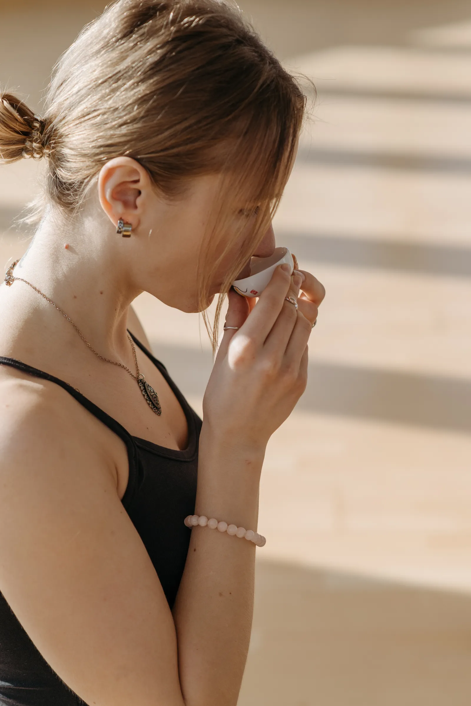 A woman peacefully enjoying a quiet moment with tea in warm sunlight